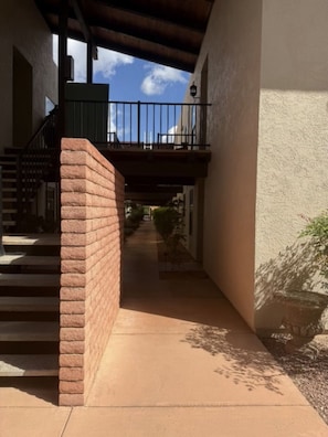 A covered outdoor area with a brick wall, a staircase, and a pathway leading to a building. - Sedona 3/2 Condo Pool - Hot Tubs - Tennis-Pickleball (Sedona)
