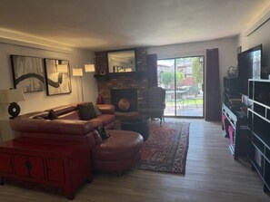 A living room with a fireplace, leather sofa, and a TV stand. - Sedona 3/2 Condo Pool - Hot Tubs - Tennis-Pickleball (Sedona)