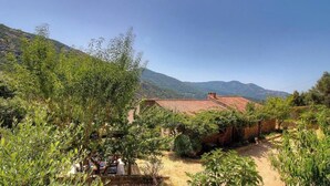 A rustic building with a red-tiled roof, surrounded by greenery and hills in the background. - La Cardiccia - BALOGNA (BALOGNA)