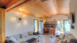 Una sala acogedora con un sofá, una mesa de centro y un televisor montado en la pared.
