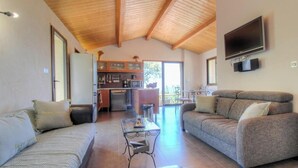 Un amplio espacio de sala con un sofá, una mesa de centro y un televisor montado en la pared.