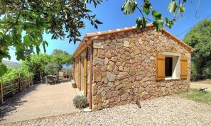 A stone building with a small window and a door, surrounded by a gravel path and greenery. - Filanciu - VIGGIANELLO (VIGGIANELLO)