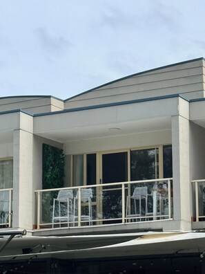 A modern building with a balcony, large windows, and a flat roof. - Sussex View | Coastal Apartment with Stunning Inlet Views (Sussex Inlet)