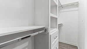 A white interior with a built-in shelf, a drawer unit, and a door with a handle. - The Cozy Ridge Apartment (Edinburg)