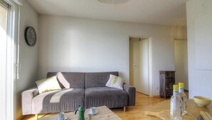 En stue med sofa, sofabord og et lille skab.