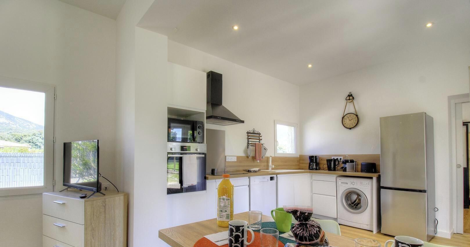 A modern kitchen with a microwave, oven, and washing machine.