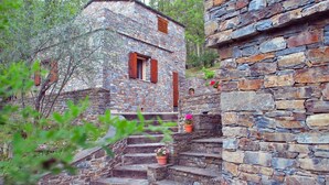 A stone building with a staircase leading to a wooden door. - Petrera 1 - CASABIANCA (CASABIANCA)