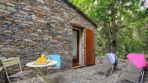 A stone building with a door, a table with drinks, and two sun loungers. - Petrera 1 - CASABIANCA (CASABIANCA)