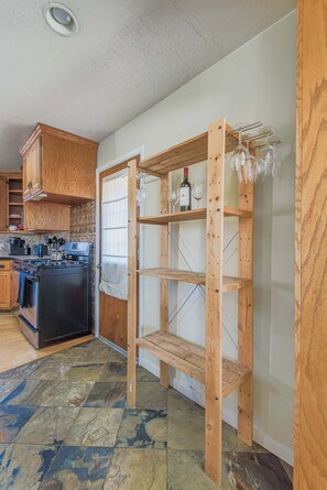 A kitchen with wooden cabinets, a stove, and a wine rack.