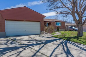 Une maison d’habitation avec un garage, un numéro bien visible « 949 » et un arbre dans le jardin.