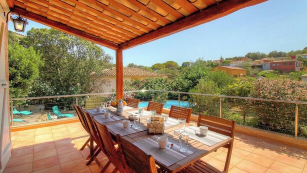 A covered outdoor dining area with a view of a swimming pool and surrounding greenery. - A Parniccia - PORTO VECCHIO (PORTO VECCHIO)