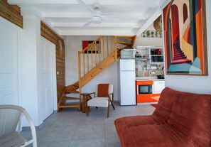 Ein zeitgemäßer Wohnraum mit Küche, Treppe und Sofa.
