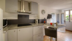 A modern kitchen with a built-in stove, a microwave, and a coffee maker on the counter.