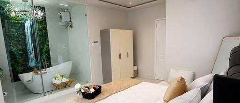 A modern bedroom with a large bed, a glass shower enclosure, and a built-in wardrobe.