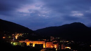 A town at dusk with illuminated buildings and a prominent castle-like structure. - Le 16402 - SARTENE - Gîte (SARTENE)