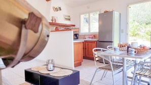 Una cucina moderna con mobili in legno, un frigorifero in acciaio inossidabile e un'area pranzo con sedie in metallo.