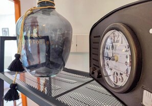 A vintage radio with a round dial and a clear glass bottle with a rope handle and tassel. - LE GENEVRIER - SERRA DI FERRO (SERRA DI FERRO)