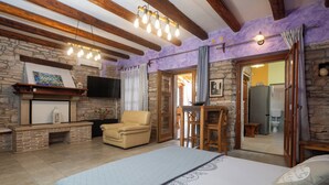 Ein Schlafzimmer mit Bett, Kamin, Fernseher und Essbereich.