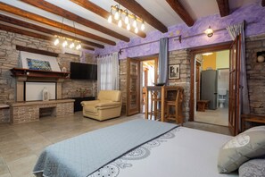 Ein Schlafzimmer mit Bett, Kamin, Fernseher und Essbereich.