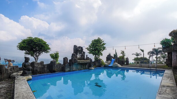 Una piscina con paisaje rocoso y estatuas.