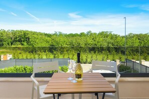 A table with a bottle and glasses, overlooking a green landscape. - Villa 4M (Istria - Pula) (Pula)