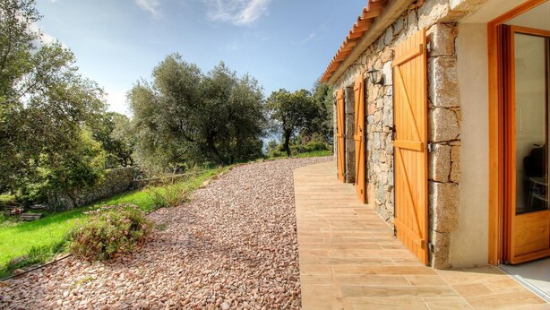 Un edificio in pietra con porte di legno e un sentiero che vi conduce.