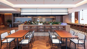 A modern restaurant with a central island, wooden tables, and chairs.
