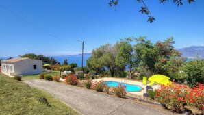 Ein Wohnhaus mit Swimmingpool, einem kleinen Haus und Meerblick.