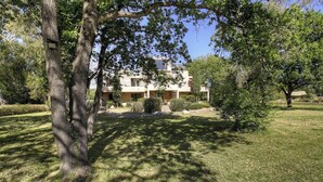 A two-story building with a well-maintained lawn and trees in the foreground. - Résidence U Quarciu - GHISONACCIA (GHISONACCIA)