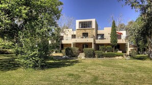 A modern two-story house with a stone facade, a balcony, and a well-maintained lawn. - Résidence U Quarciu - GHISONACCIA (GHISONACCIA)