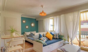 Un dormitorio con cama, escritorio, silla, planta en maceta y ventana con cortinas.