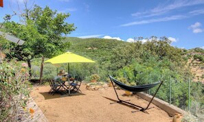 An outdoor patio with a table, chairs, a yellow umbrella, and a hammock. - L'ORMEAU - SERRA DI FERRO (SERRA DI FERRO)