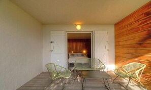 Ein Balkon mit einem Bett, zwei Stühlen und einem Tisch.