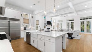 A spacious kitchen with white cabinetry, a large island, and pendant lighting. - Screened-in Pool, LSV/Golf Cart, & Bikes! Carriage House! Walk to Beach! (Santa Rosa Beach)