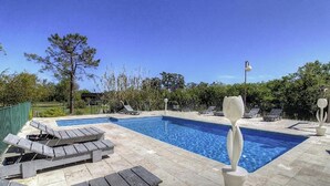 A swimming pool with lounge chairs and a decorative sculpture. - Résidence U Quarciu - GHISONACCIA (GHISONACCIA)