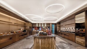 Un moderno vestíbulo de hotel con una isla central, un mostrador de recepción y una zona de bar.