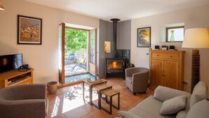 Un salon avec une cheminée, un téléviseur et un canapé.