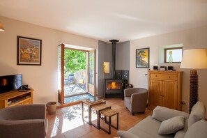 A living room with a fireplace, a television, and a sofa. - U Rataghju - LA PORTA (LA PORTA)