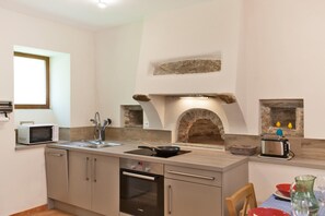 A compact kitchen with a built-in oven, a microwave, a stone oven, and a toaster. - U Rataghju - LA PORTA (LA PORTA)