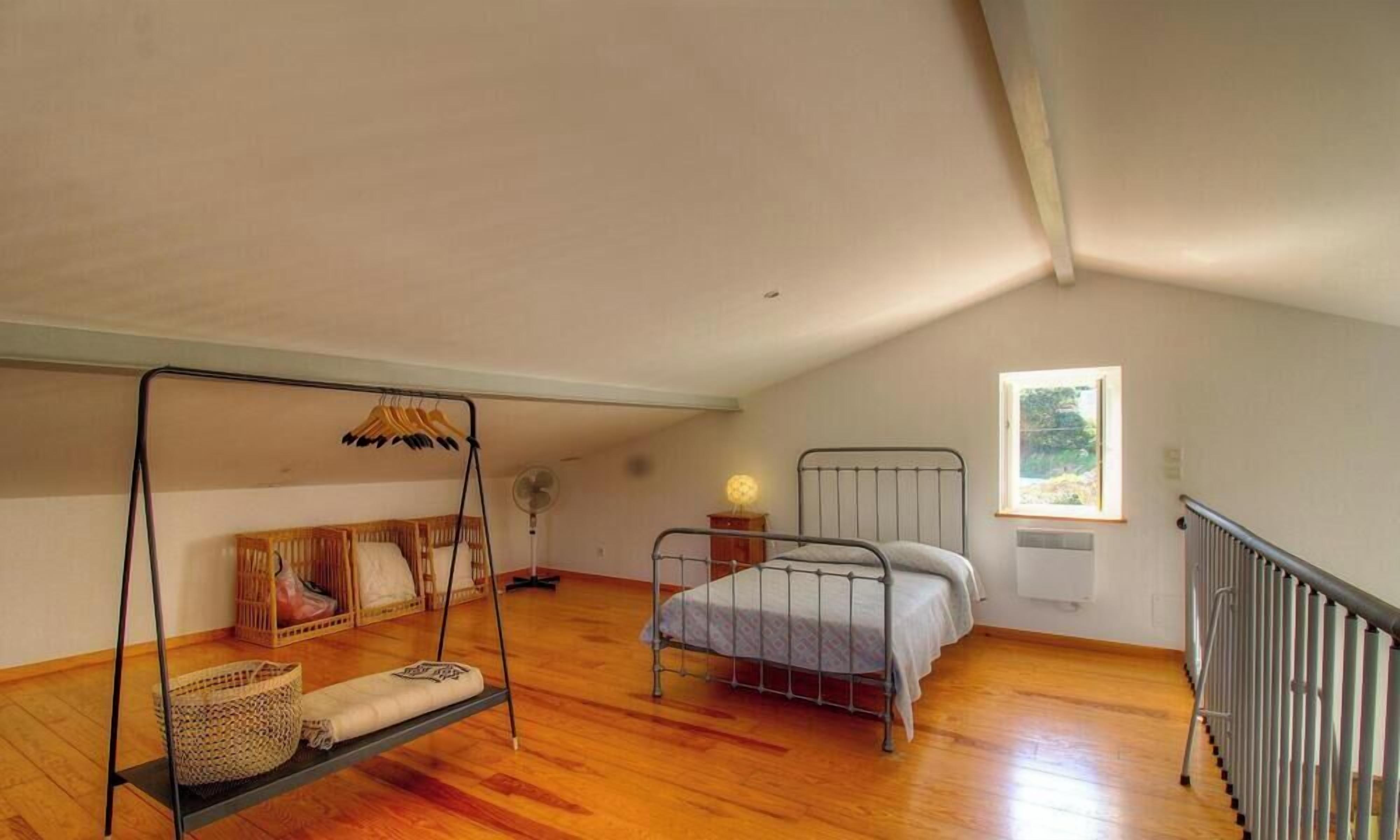 A bedroom with a swing, a bed, a window, and a radiator.