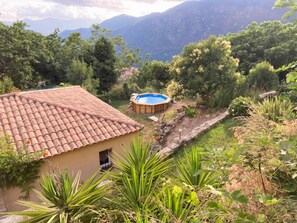Una casa amb teulada, piscina i vegetació als voltants.
