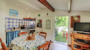 Eine gemütliche Küche mit Essbereich, Fernseher und Blick auf den Garten.