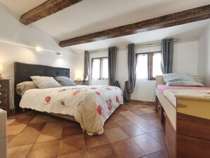 A bedroom with two beds, a wooden ceiling, and a tiled floor. - Macadia - AULLENE - Gîte (AULLENE)