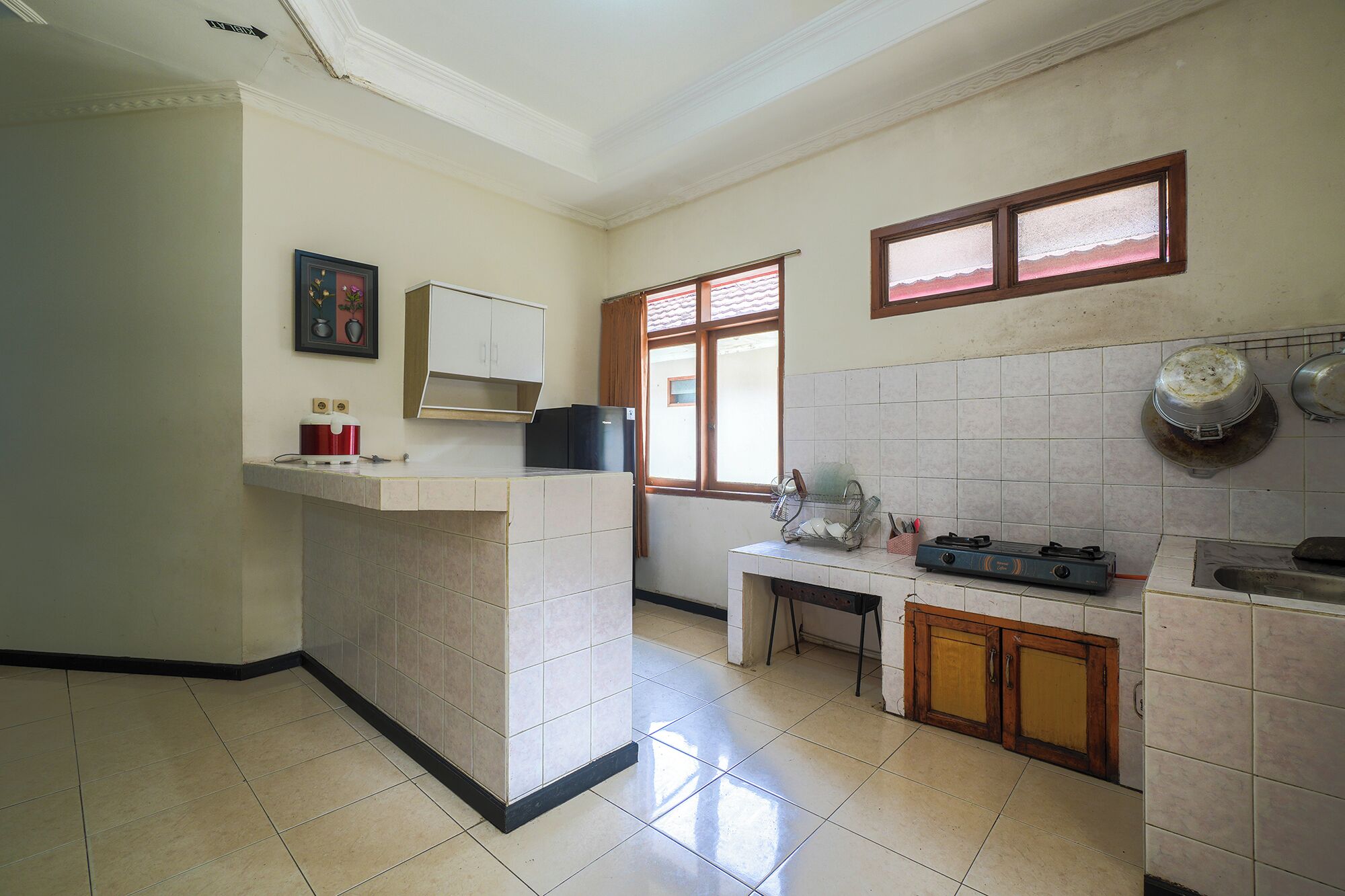A kitchen with a central island, a window, and tiled walls.