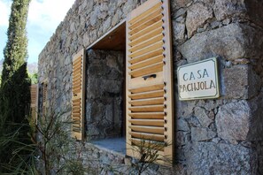 A stone building with wooden shutters and a sign reading 'CASA PACHJOLA'. - Casa Pachjola - URTACA (URTACA)