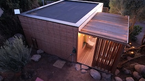 A small wooden cabin with a sloped roof, a wooden deck, and a small outdoor seating area. - Pasciale delia Lucia (SAINTE LUCIE DE PORTO VECCHIO)