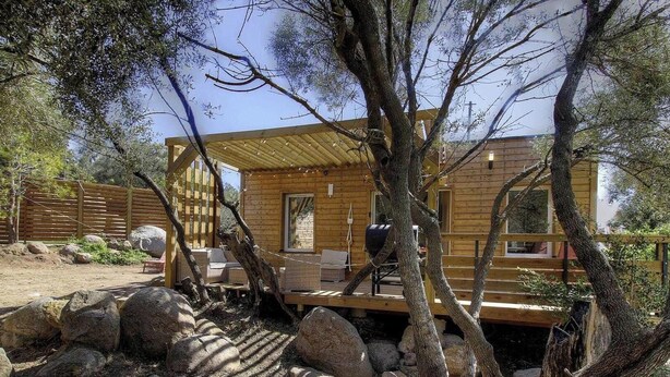 A wooden cabin with a deck, surrounded by trees and rocks. - Pasciale delia Lucia (SAINTE LUCIE DE PORTO VECCHIO)