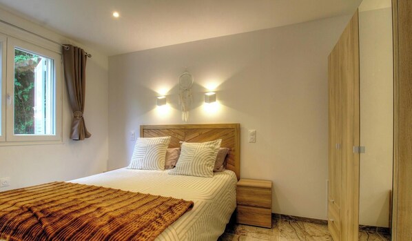 A bedroom with a bed, bedside tables, a wardrobe, and a window with curtains. - U SOGNU - MARIGNANA - Gîte (MARIGNANA)