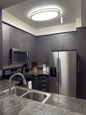 A modern kitchen with a stainless steel refrigerator, microwave, and gas stove. - Elegant 1-bedroom apartment in tranquil Marina del Rey (Marina del Rey)