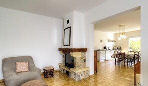 A living room with a fireplace, a dining area, and a kitchen. - A Traversa - PRUNELLI DI FIUMORBO (PRUNELLI DI FIUMORBO)